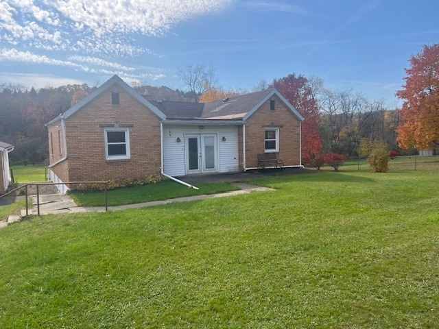 back of property featuring a yard and french doors