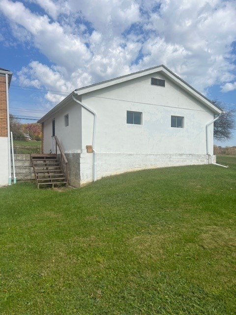 view of property exterior with a yard