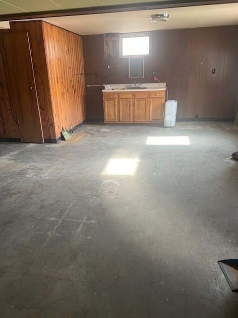 basement featuring wood walls and sink