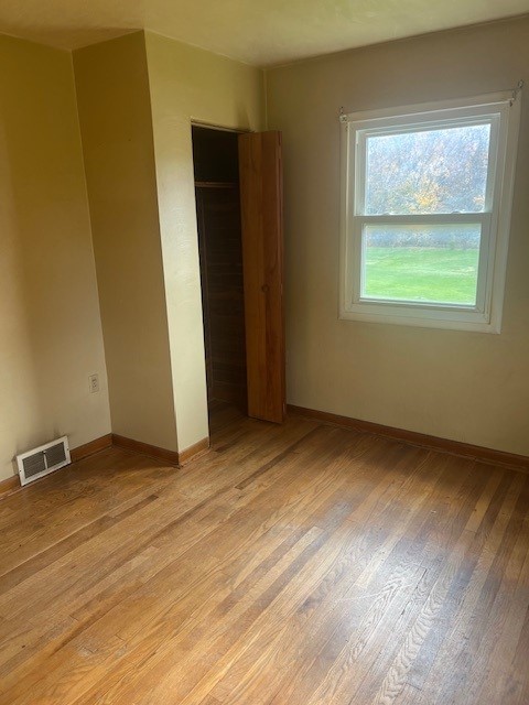 unfurnished bedroom featuring a closet and light hardwood / wood-style floors