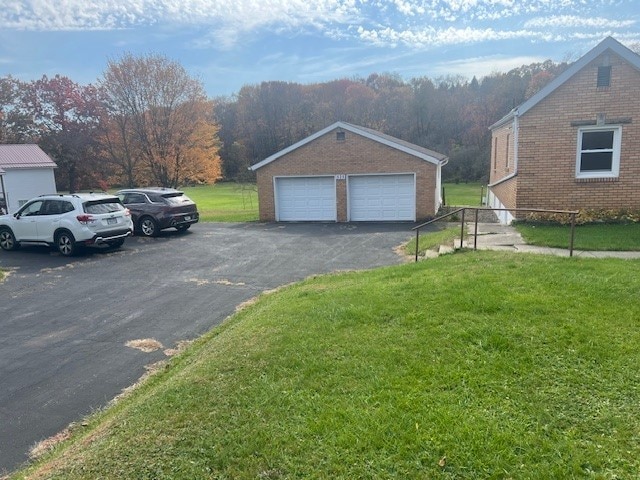 view of side of property with a yard, an outbuilding, and a garage