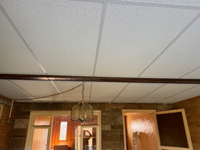 details featuring a paneled ceiling and a chandelier