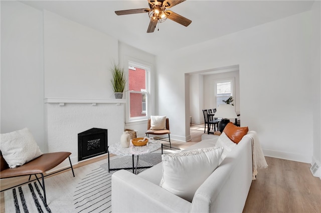 living room with ceiling fan and light hardwood / wood-style flooring