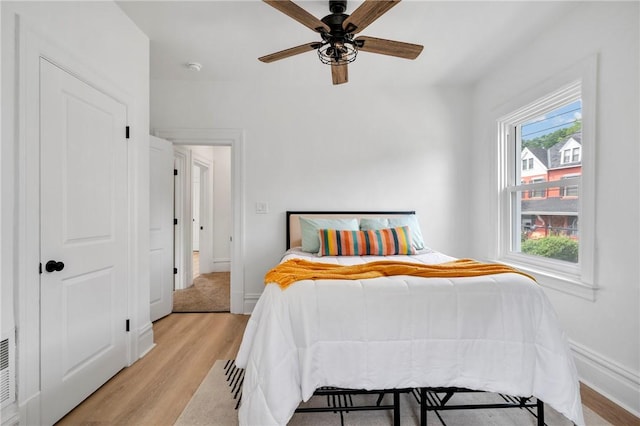 bedroom featuring multiple windows, ceiling fan, and light hardwood / wood-style flooring