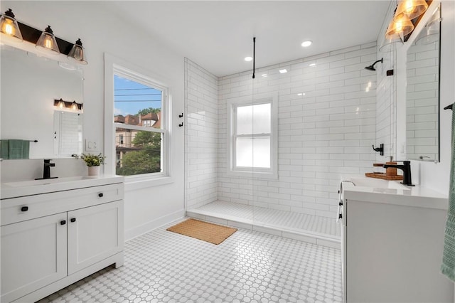 bathroom with a tile shower, vanity, and tile patterned floors