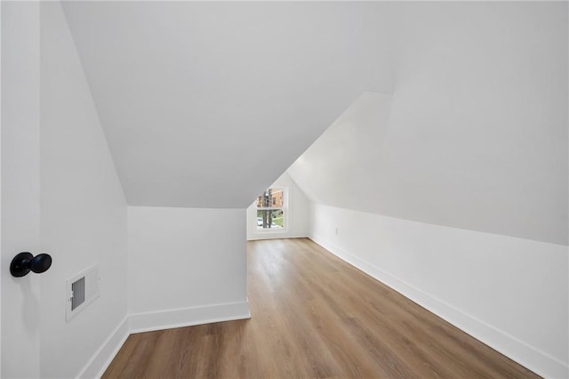 bonus room with lofted ceiling and light hardwood / wood-style flooring