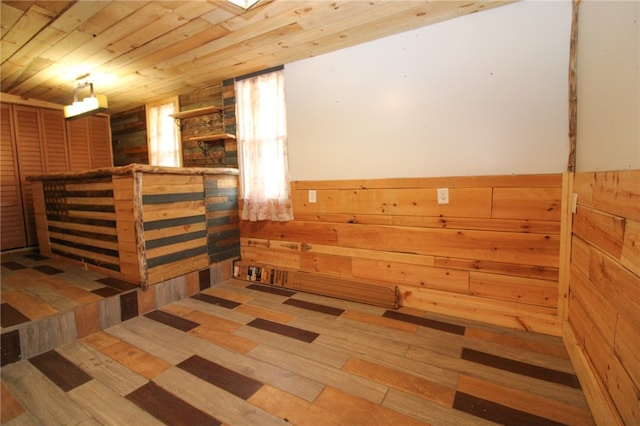 interior space featuring wood walls, hardwood / wood-style floors, and wood ceiling