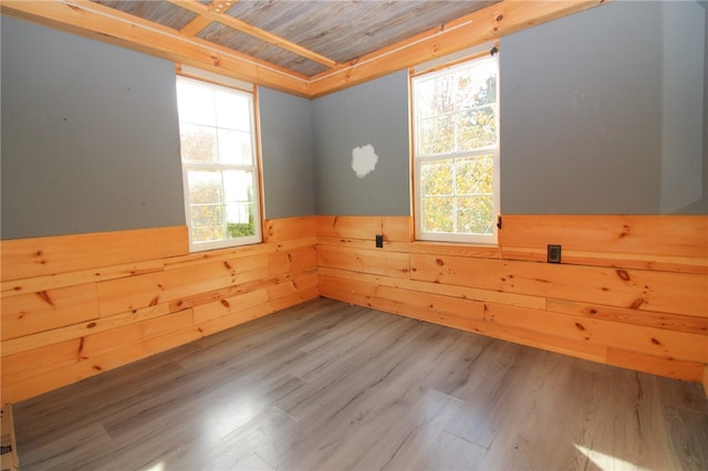 empty room featuring hardwood / wood-style floors, wooden walls, and wood ceiling