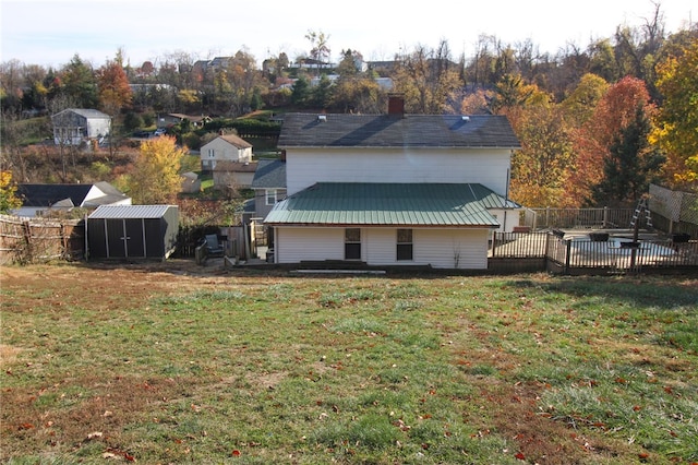 back of house featuring a yard and a storage shed