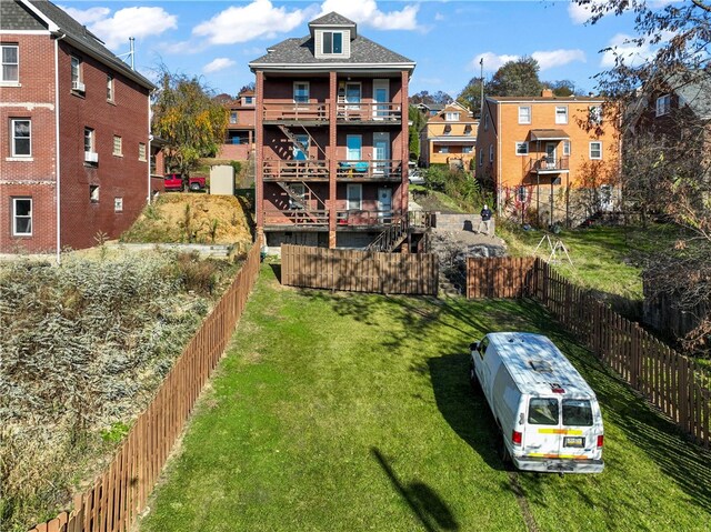 exterior space featuring a lawn and a balcony