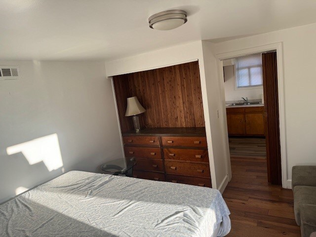 bedroom featuring sink and dark hardwood / wood-style flooring