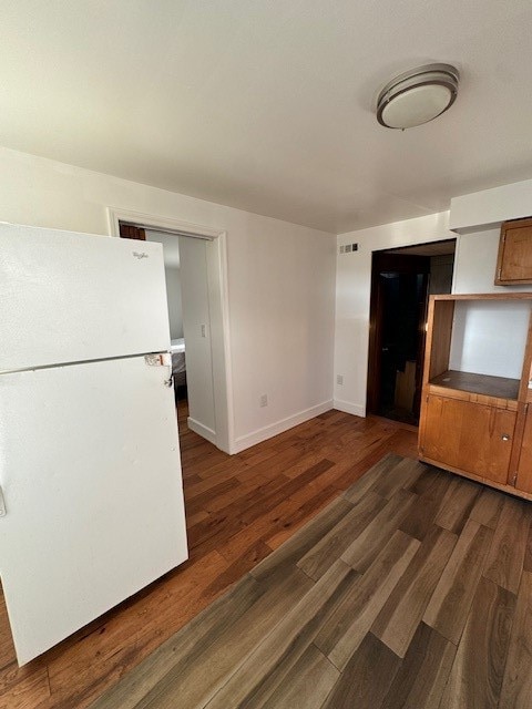 interior space with dark hardwood / wood-style floors and white fridge