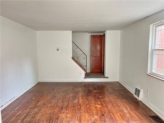 unfurnished room featuring a healthy amount of sunlight and dark hardwood / wood-style flooring