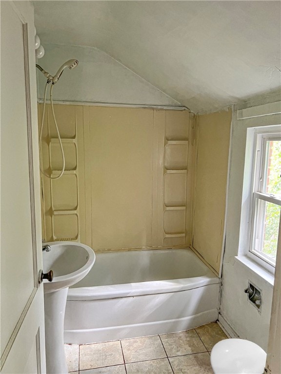 bathroom with tile patterned floors, vaulted ceiling, toilet, and shower / bathtub combination