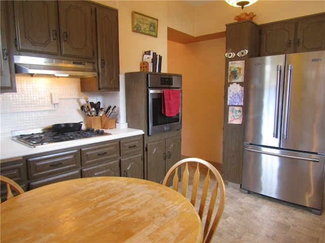 kitchen featuring stainless steel appliances, backsplash, and dark brown cabinetry