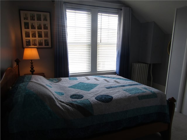 bedroom featuring radiator and lofted ceiling