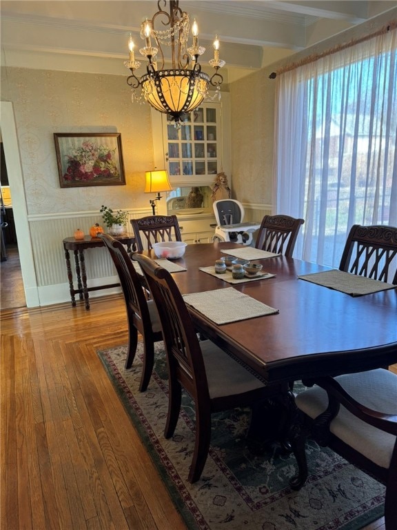 dining room featuring an inviting chandelier, beamed ceiling, and wood-type flooring