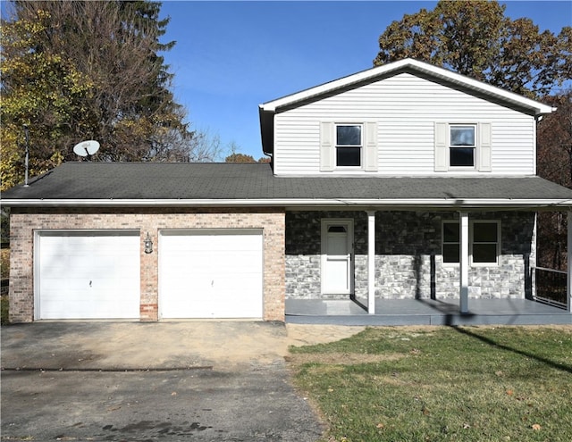 view of front property featuring covered porch, a front yard, and a garage