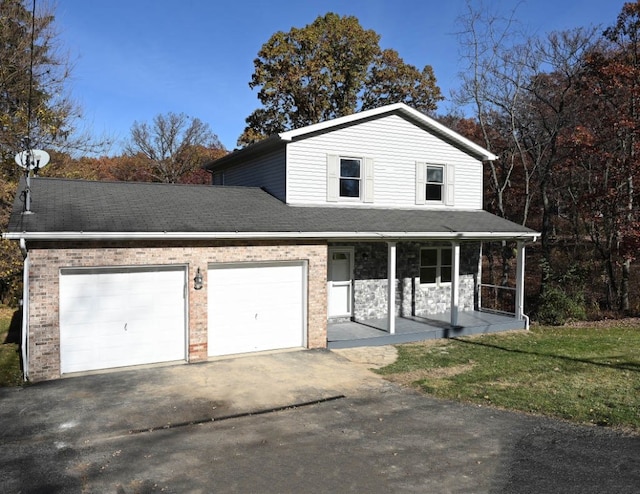 view of property with a porch, a front lawn, and a garage