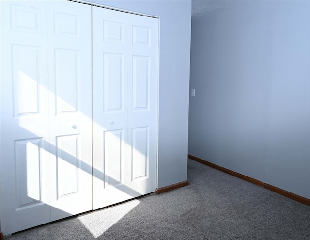 unfurnished bedroom featuring a closet and dark colored carpet