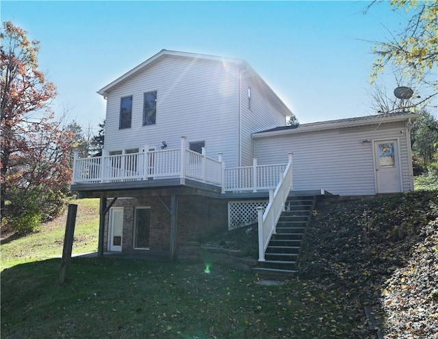 back of property featuring a deck and a lawn