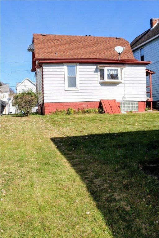 rear view of house featuring a yard