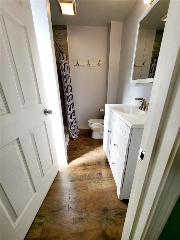 bathroom featuring vanity, curtained shower, hardwood / wood-style flooring, and toilet