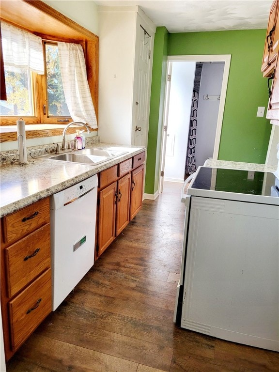 kitchen featuring white dishwasher, stove, sink, and dark hardwood / wood-style flooring