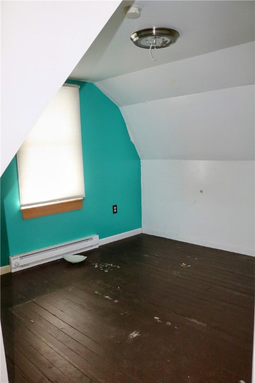 additional living space with lofted ceiling, a baseboard heating unit, and dark wood-type flooring