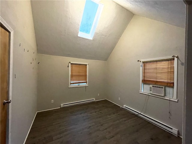 additional living space featuring vaulted ceiling with skylight, dark hardwood / wood-style floors, cooling unit, and a baseboard radiator