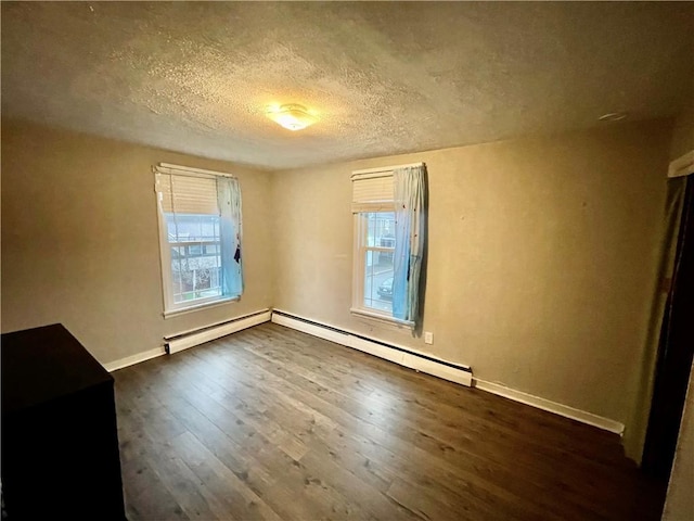 spare room featuring a textured ceiling, dark hardwood / wood-style flooring, and baseboard heating