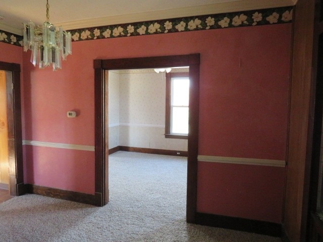 corridor with a chandelier and carpet