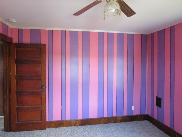 carpeted empty room with ornamental molding and ceiling fan