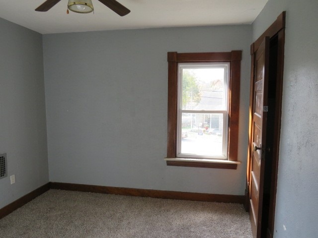 carpeted empty room featuring ceiling fan