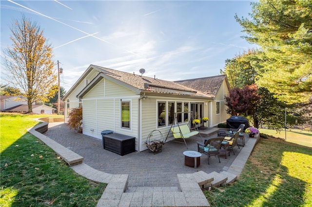 back of house with an outdoor fire pit, a yard, and a patio