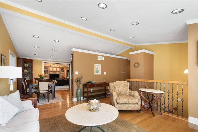 living room featuring lofted ceiling, hardwood / wood-style flooring, and crown molding