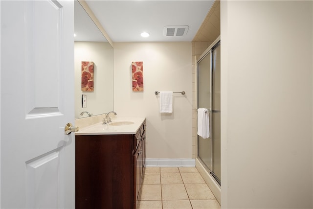 bathroom with walk in shower, vanity, and tile patterned floors