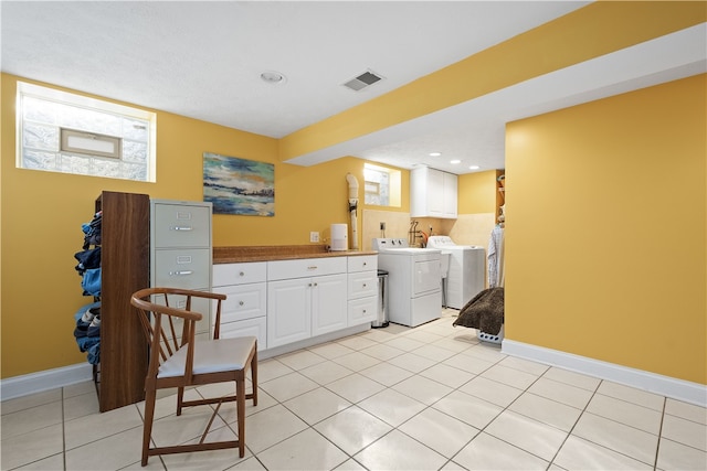 laundry area with cabinets, light tile patterned flooring, and washer and dryer