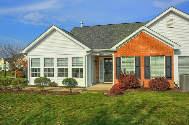 view of front of home featuring a front yard and cooling unit