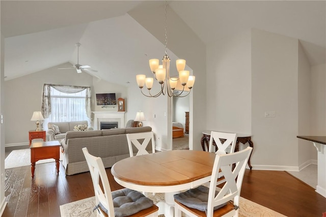 dining room with dark hardwood / wood-style floors, lofted ceiling, and ceiling fan with notable chandelier