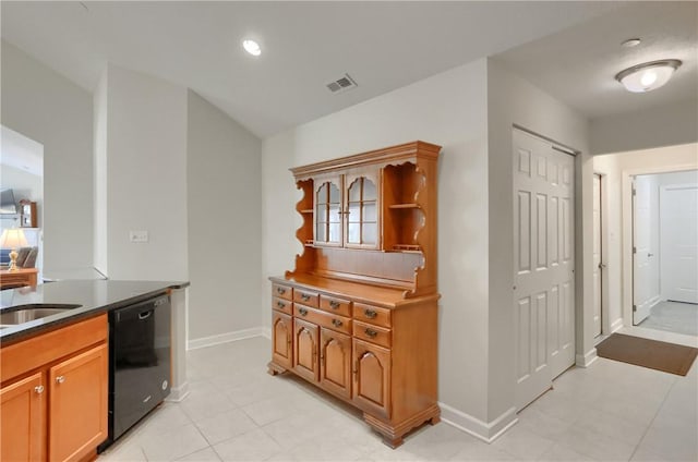 kitchen featuring sink, light tile patterned floors, and black dishwasher