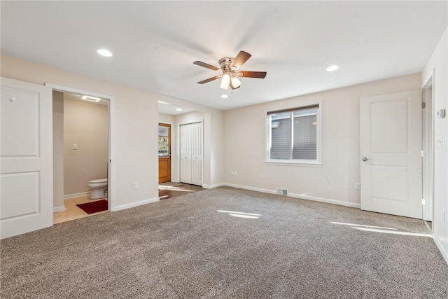 unfurnished bedroom featuring ensuite bathroom, ceiling fan, carpet flooring, and a closet