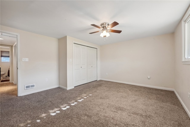 unfurnished bedroom with multiple windows, carpet floors, ceiling fan, and a closet