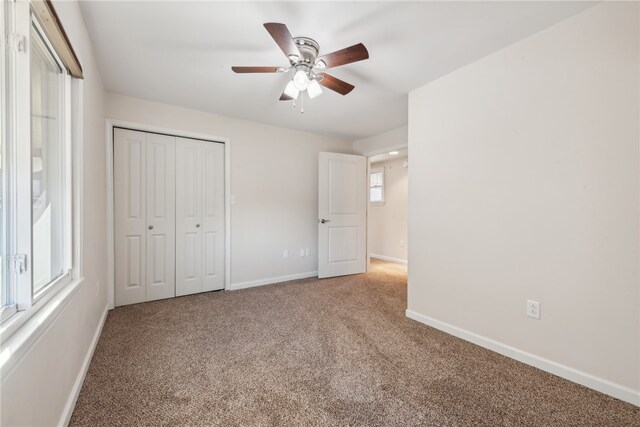 unfurnished bedroom featuring a closet, carpet, and ceiling fan