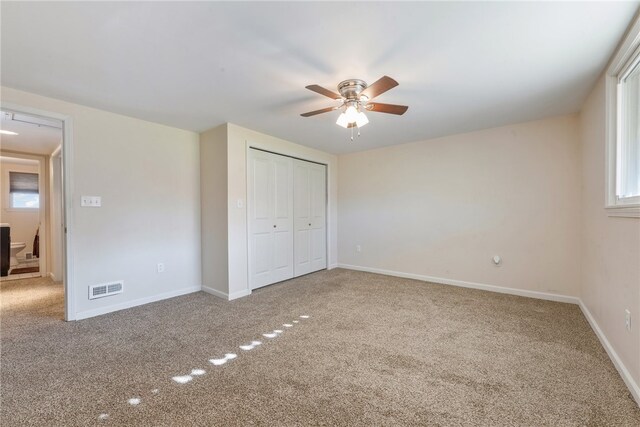 unfurnished bedroom with multiple windows, carpet floors, and ceiling fan