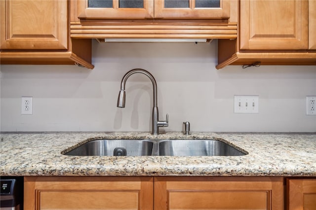 kitchen featuring light stone countertops, sink, and dishwasher