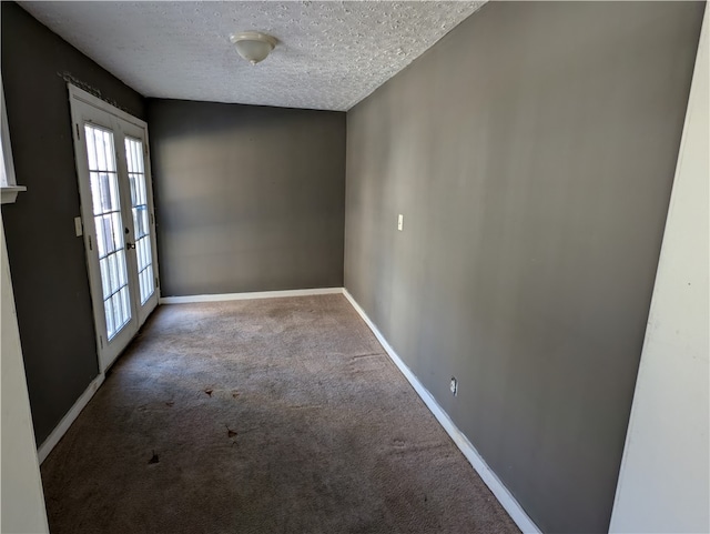 carpeted empty room featuring french doors and a textured ceiling