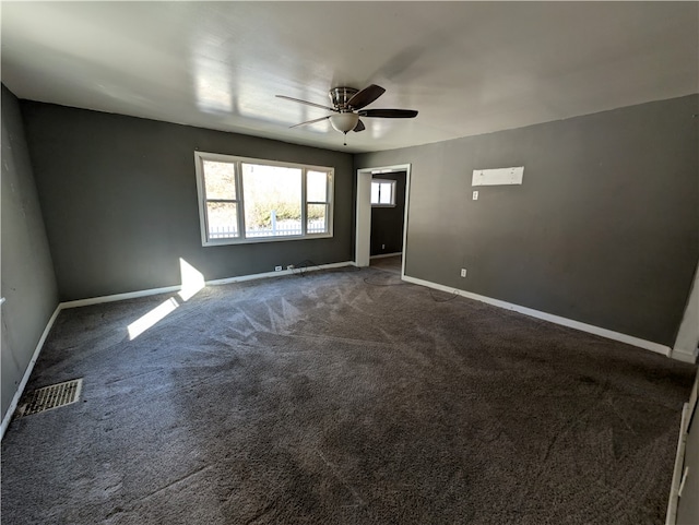 empty room featuring ceiling fan and carpet