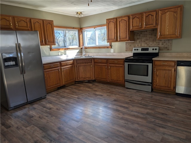 kitchen featuring crown molding, stainless steel appliances, backsplash, dark hardwood / wood-style floors, and sink