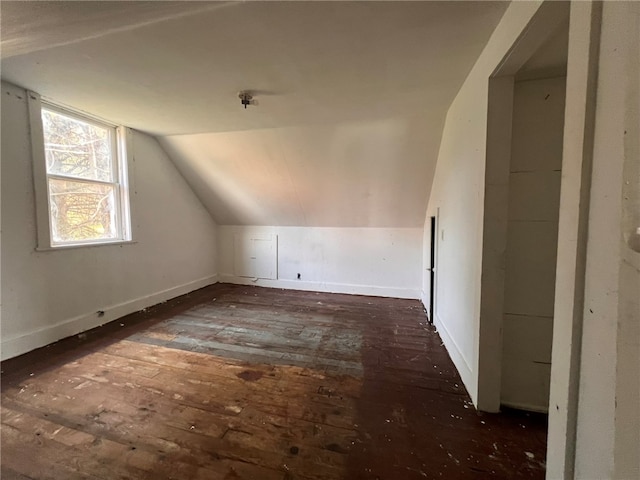 bonus room with dark hardwood / wood-style flooring and vaulted ceiling